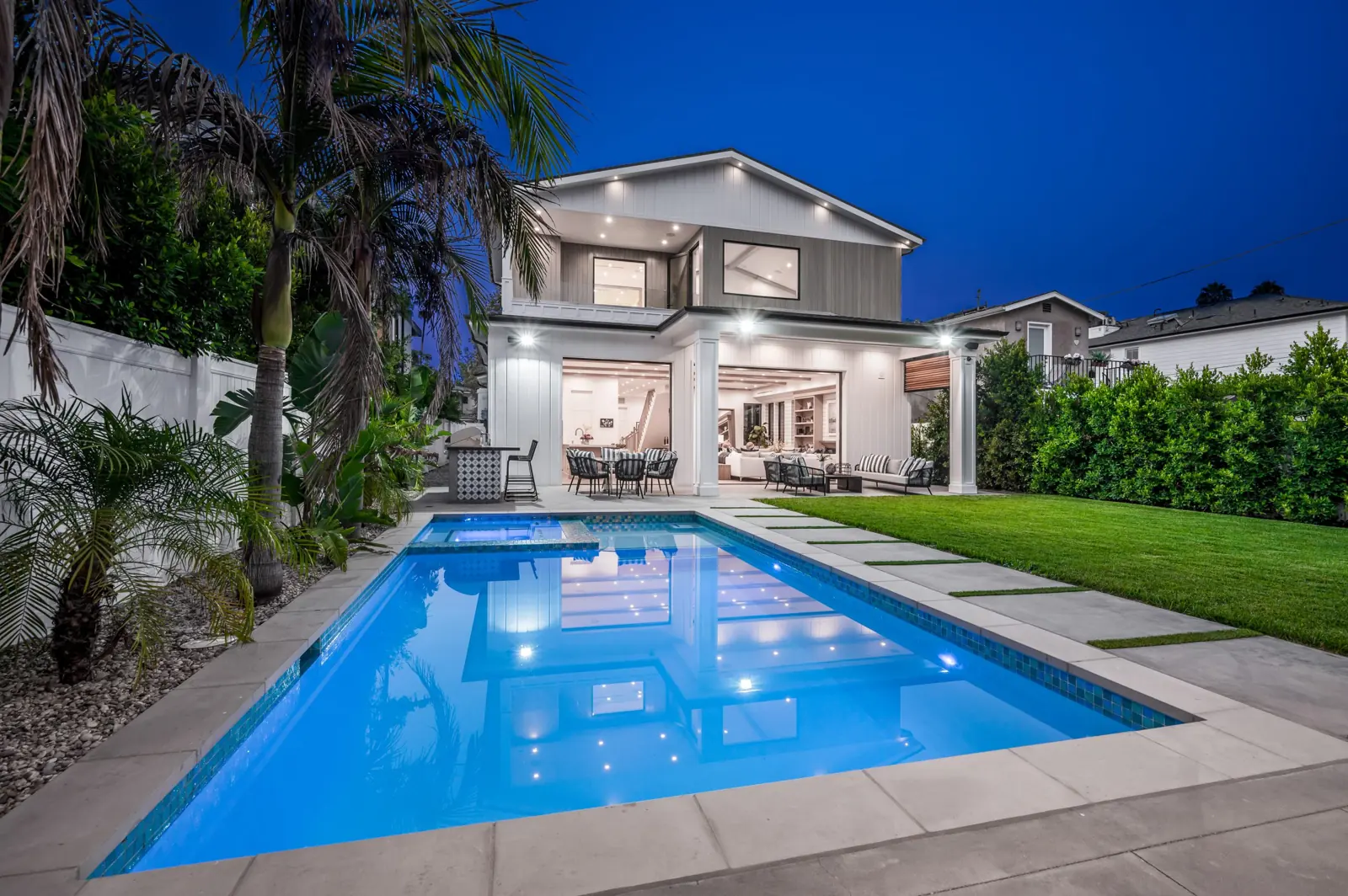 A backyard pool glowing at dusk