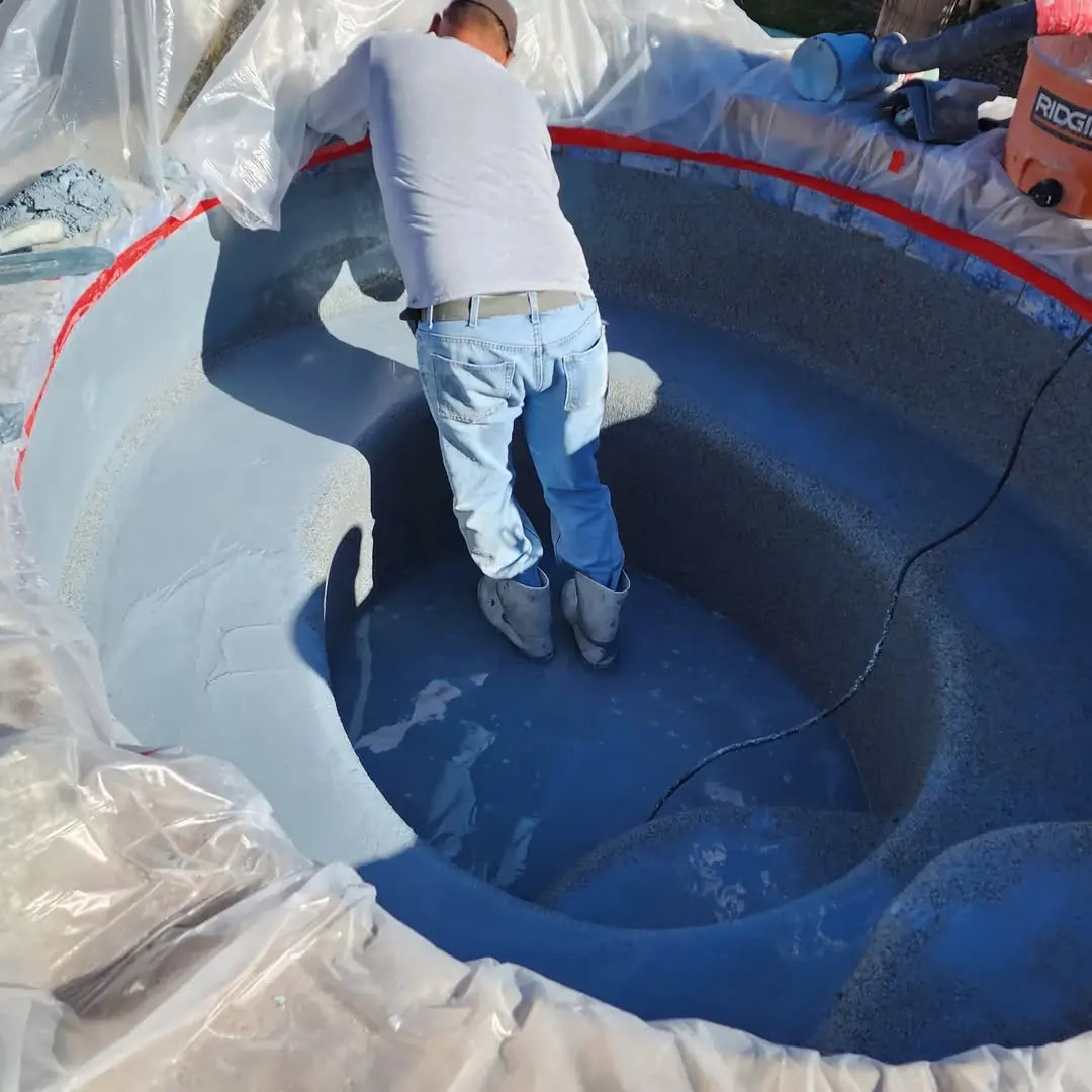A crew member applying a pebble finish in a spa