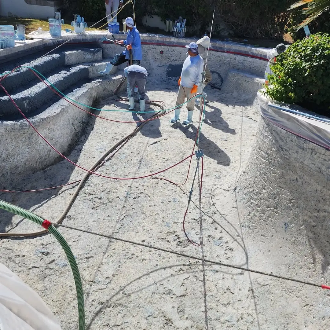 Crew resurfacing a pool interior
