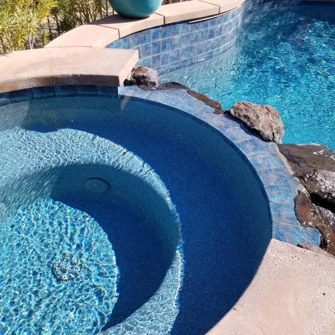 Rounded spa with a blue pebble finish